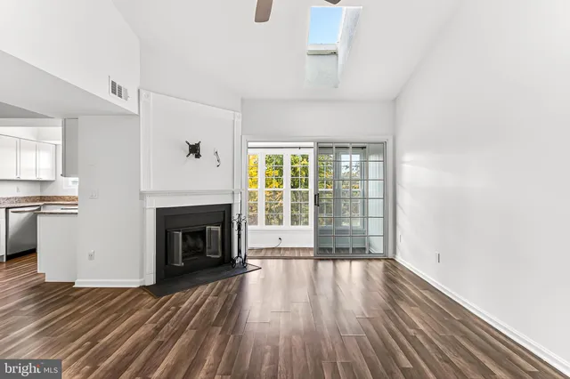 a view of wooden floor fire place and windows in a room