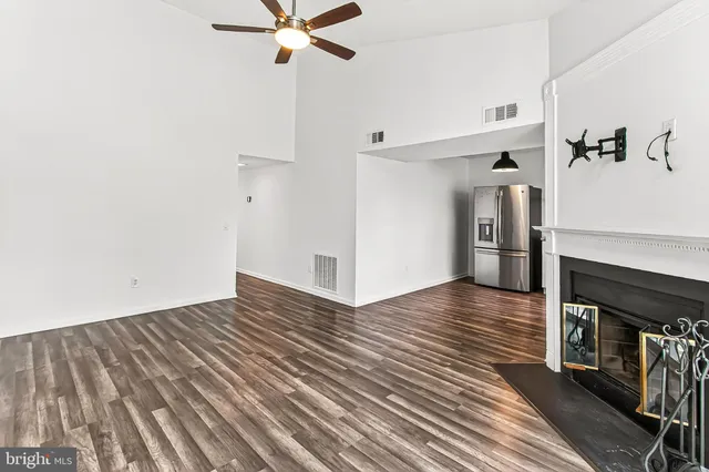a view of a livingroom with wooden floor and a ceiling fan