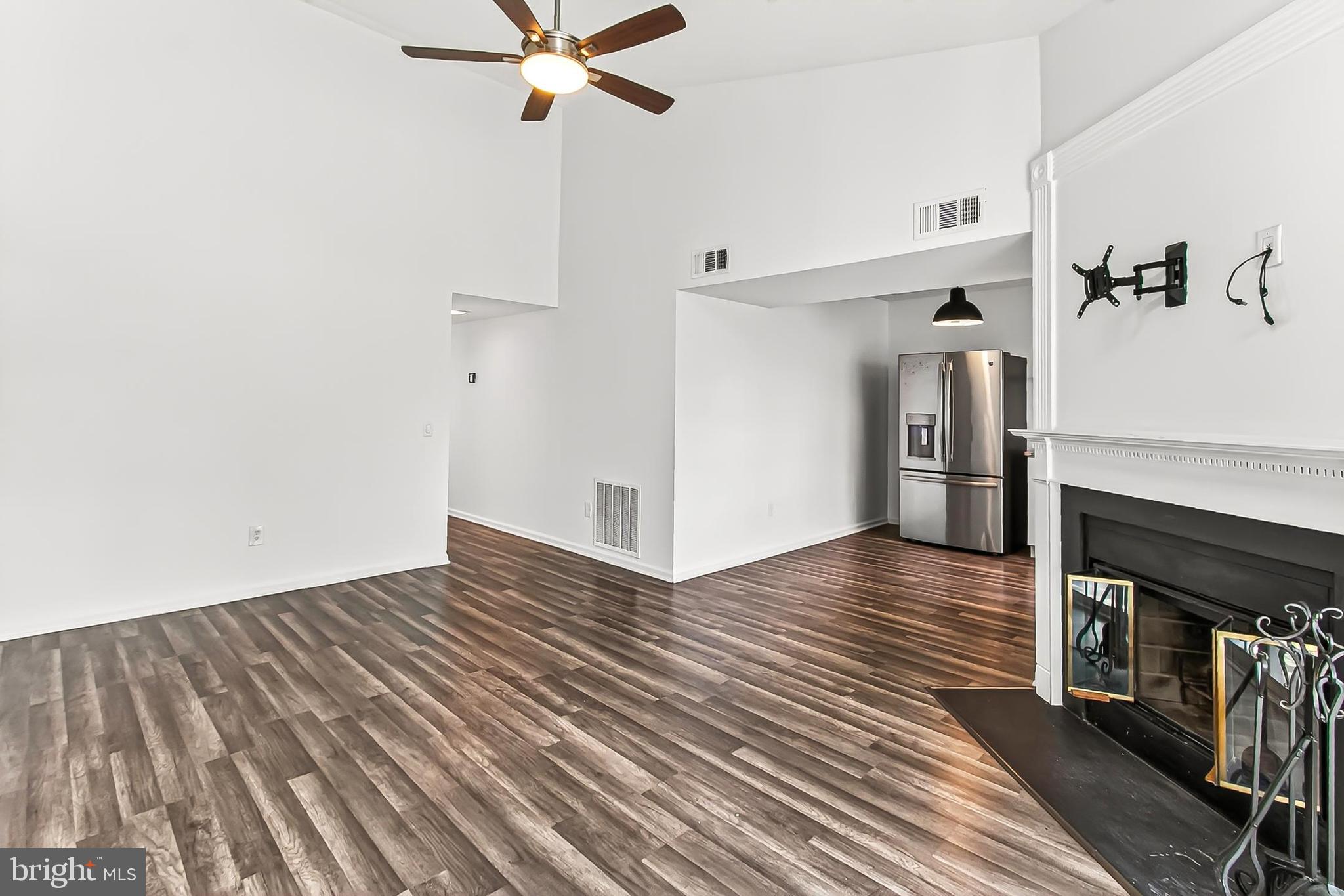120 Prosperity Avenue Southeast, Unit E Leesburg, VA 20175 - Photo 10 of 34 a view of a livingroom with wooden floor and a ceiling fan