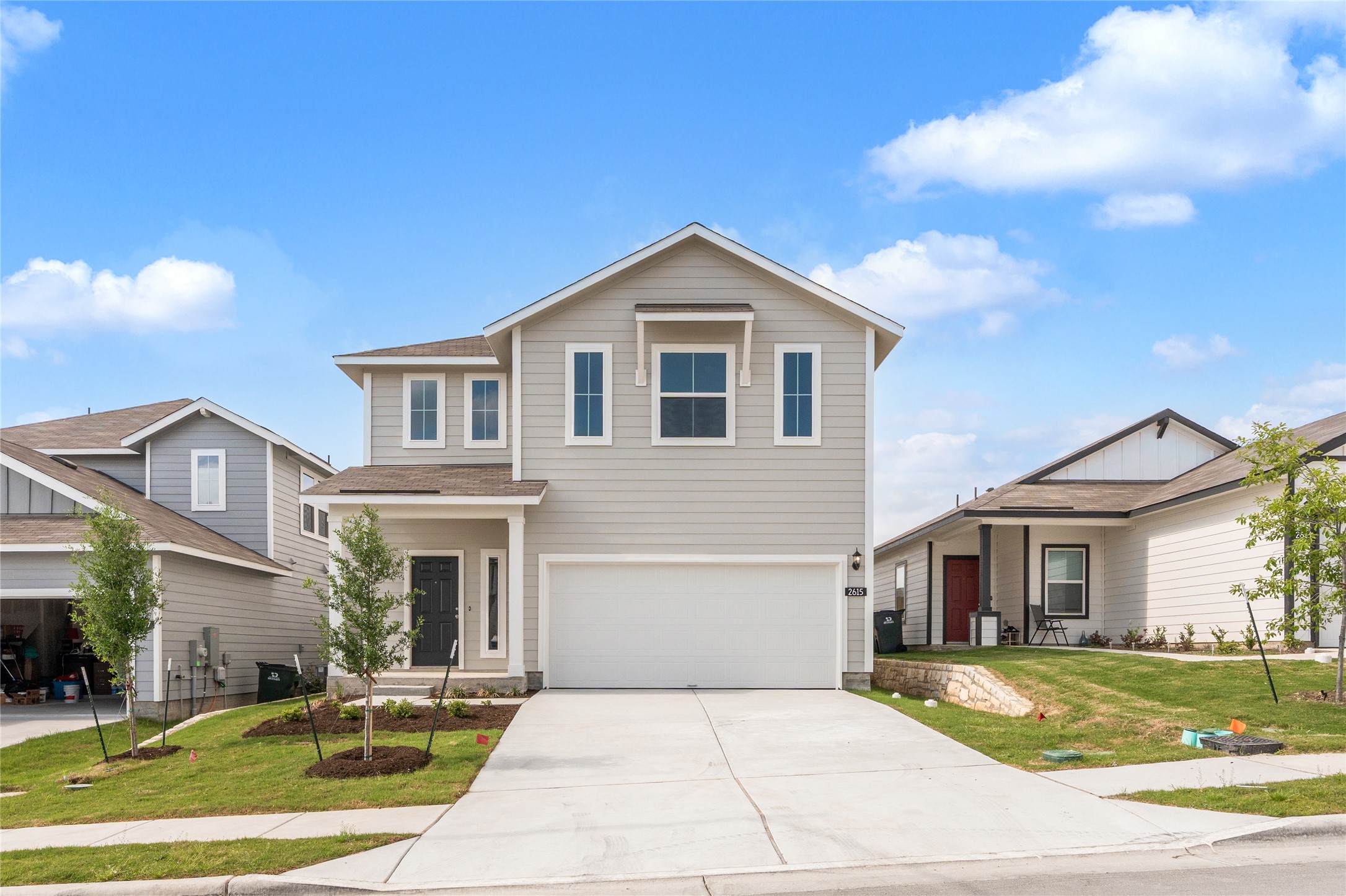 Traditional-style home with driveway, a front yard, and a garage