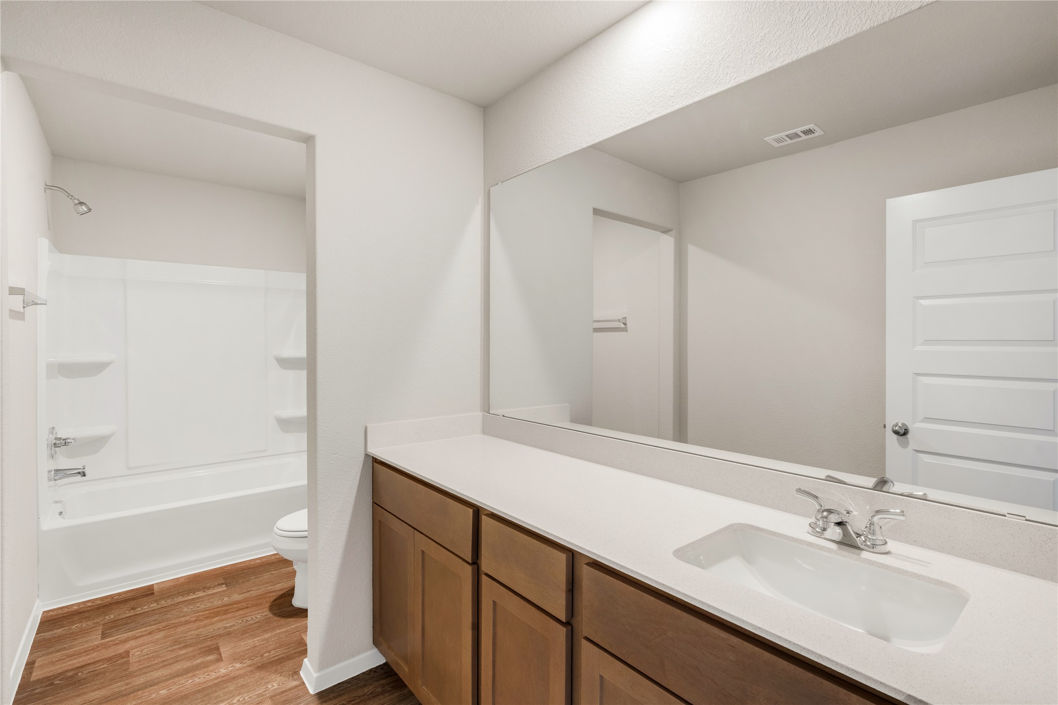 2615 Towy Road Manor, TX 78653 - Photo 25 of 38 Bathroom with vanity, bathing tub / shower combination, and light wood-style flooring