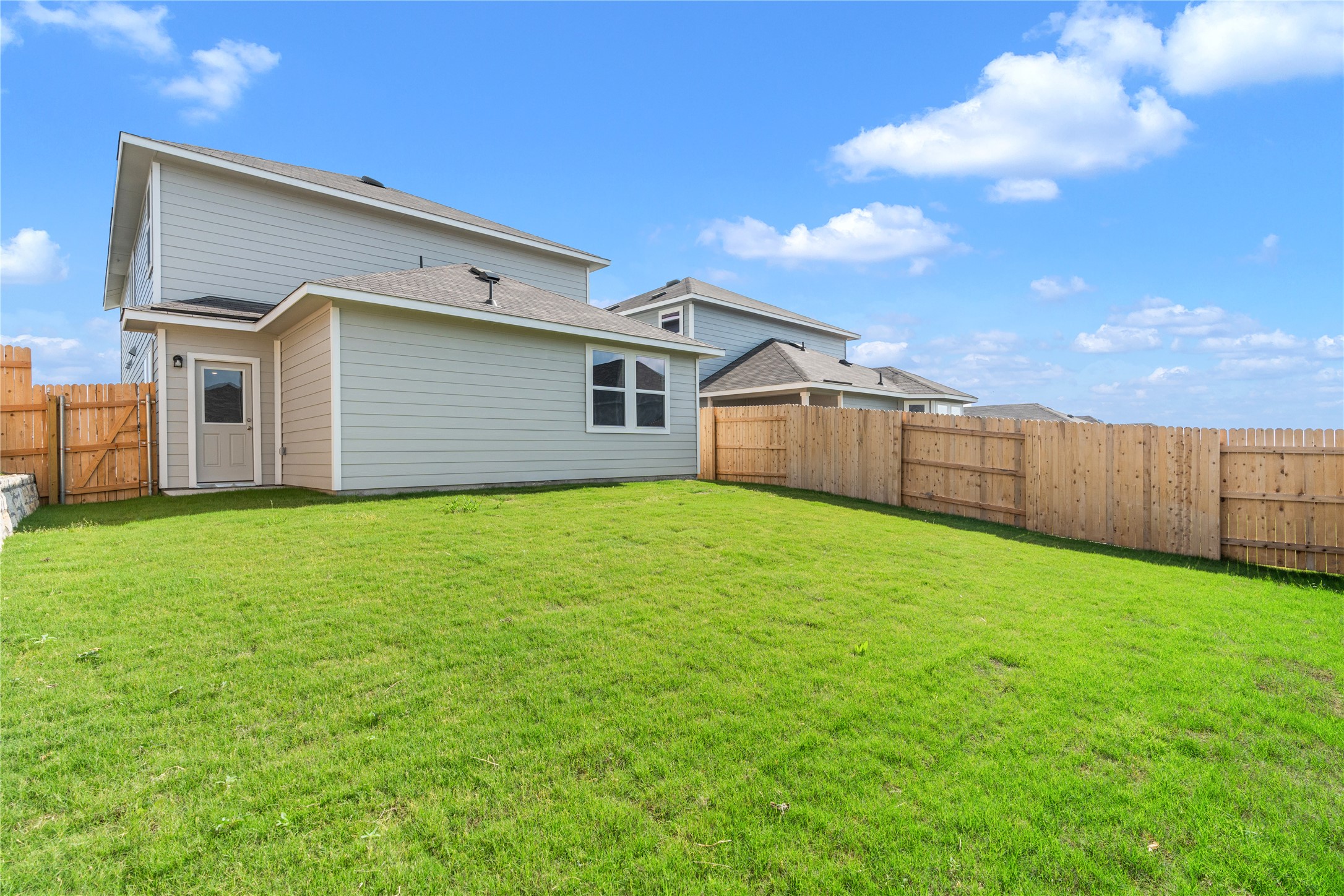 2615 Towy Road Manor, TX 78653 - Photo 32 of 38 Back of property with a fenced backyard and a gate