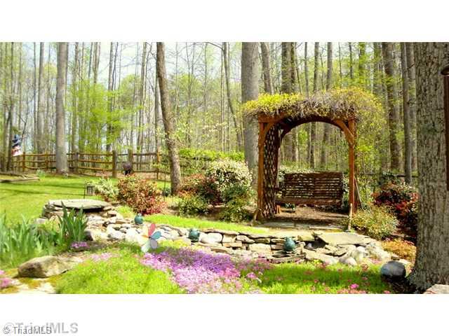 6689 Currieton Drive Oak Ridge, NC 27310 - Photo 13 of 16 Yard/Garden. Listen to the tranquil water fall feature while relaxing in the swing