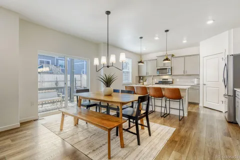 a view of a dining room and livingroom with furniture wooden floor a chandelier