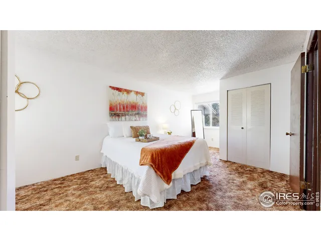 a living room with a bed and a painting on the wall