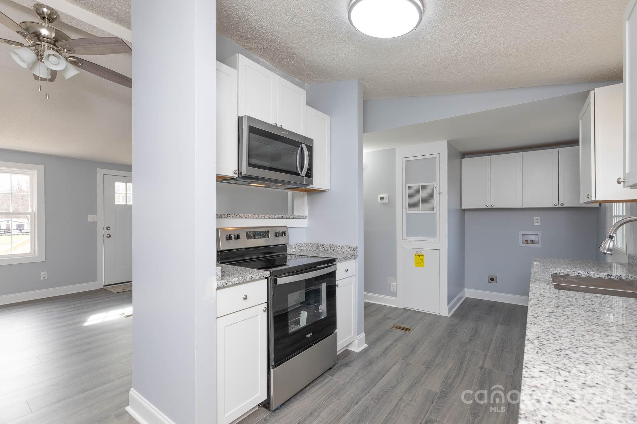154 Brown Neal Road York, SC 29745 - Photo 8 of 24 a kitchen with stainless steel appliances a stove top oven a sink and a refrigerator