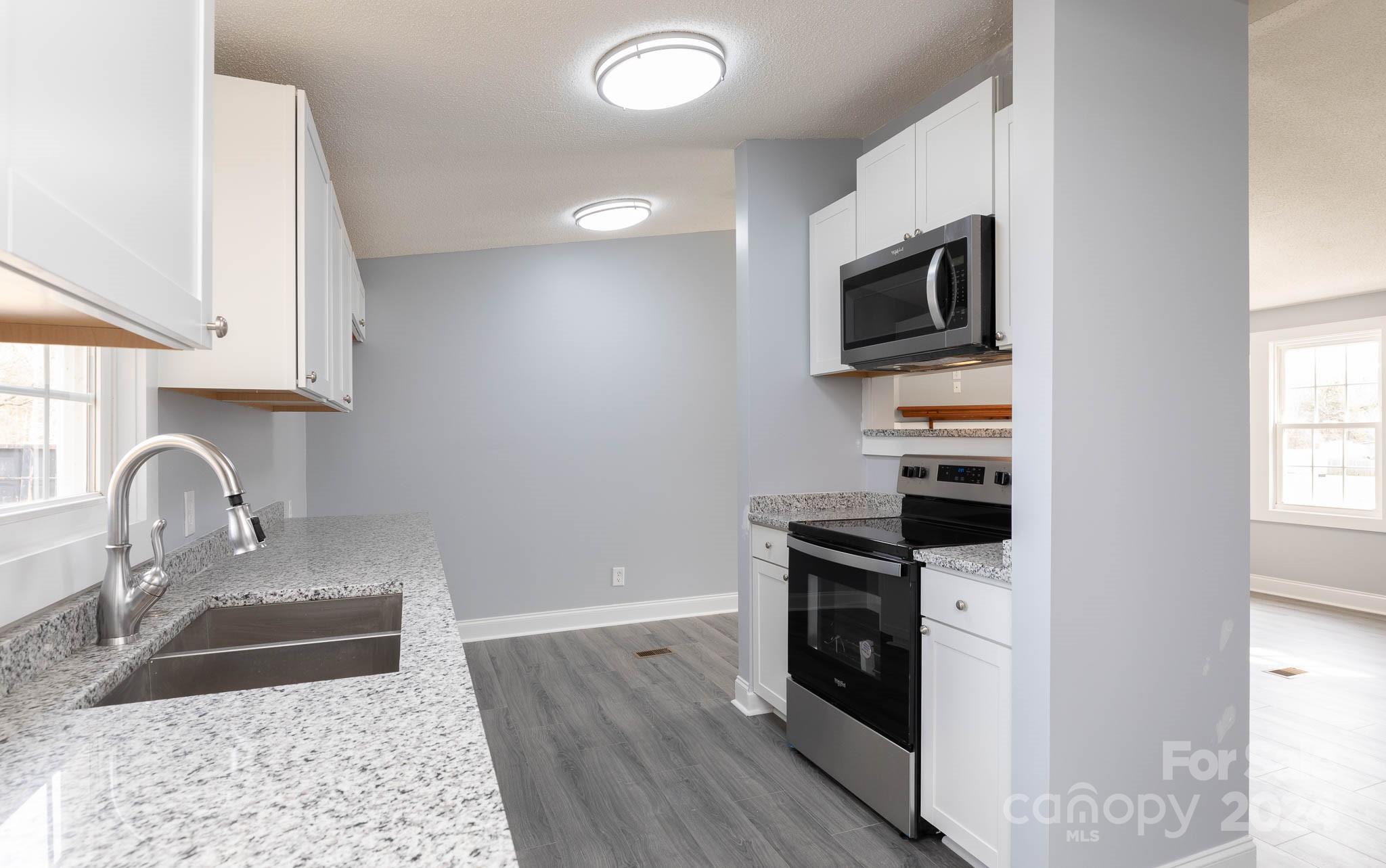 154 Brown Neal Road York, SC 29745 - Photo 10 of 24 a kitchen with stainless steel appliances granite countertop a sink stove and microwave