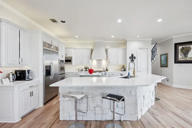 a kitchen with kitchen island a white counter top space cabinets and stainless steel appliances