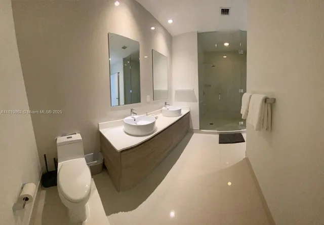 a bathroom with a sink a toilet and shower