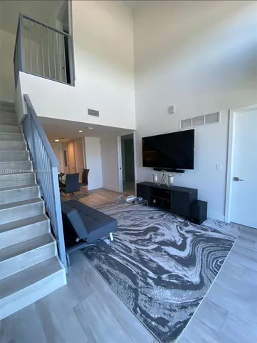 a living room with wooden floor and a flat screen tv
