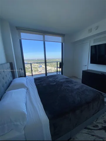 a living room with a bed furniture and a large window