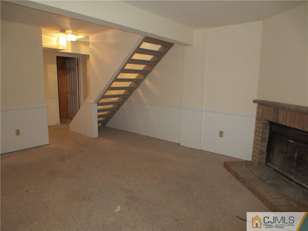 675 Bound Brook Road, Unit 23 Dunellen, NJ 08812 - Photo 14 of 26 a view of an empty room with stairs and a fireplace