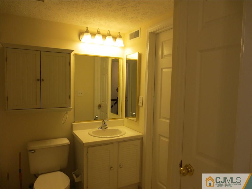 675 Bound Brook Road, Unit 23 Dunellen, NJ 08812 - Photo 23 of 26 a bathroom with a sink mirror and toilet