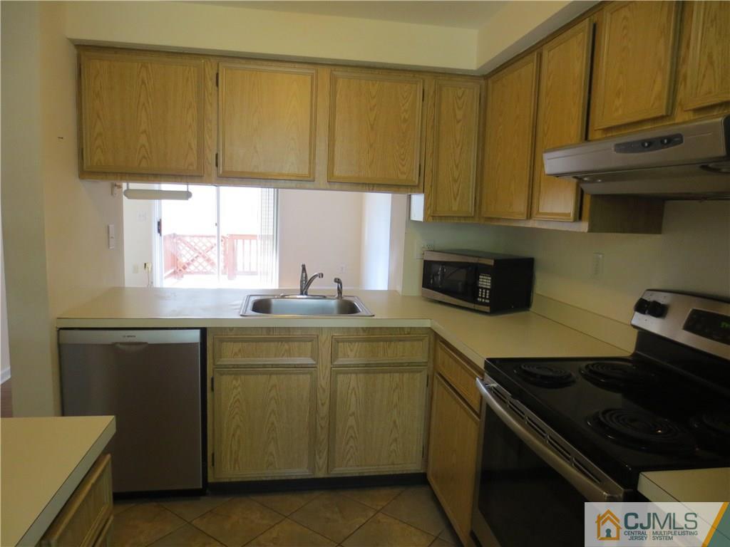 675 Bound Brook Road, Unit 23 Dunellen, NJ 08812 - Photo 6 of 26 a kitchen with stainless steel appliances a stove a sink and a microwave