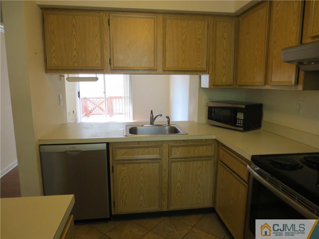 675 Bound Brook Road, Unit 23 Dunellen, NJ 08812 - Photo 7 of 26 a kitchen with a sink cabinets and a window