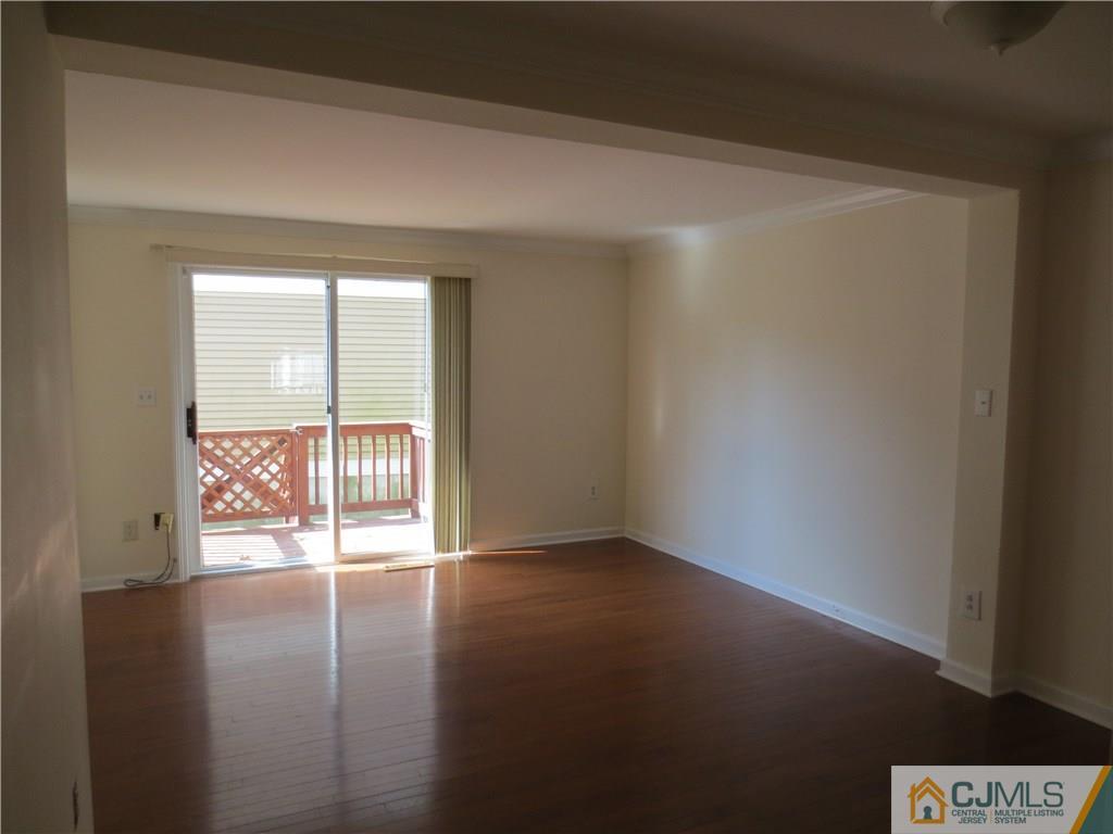 675 Bound Brook Road, Unit 23 Dunellen, NJ 08812 - Photo 9 of 26 an empty room with wooden floor and windows