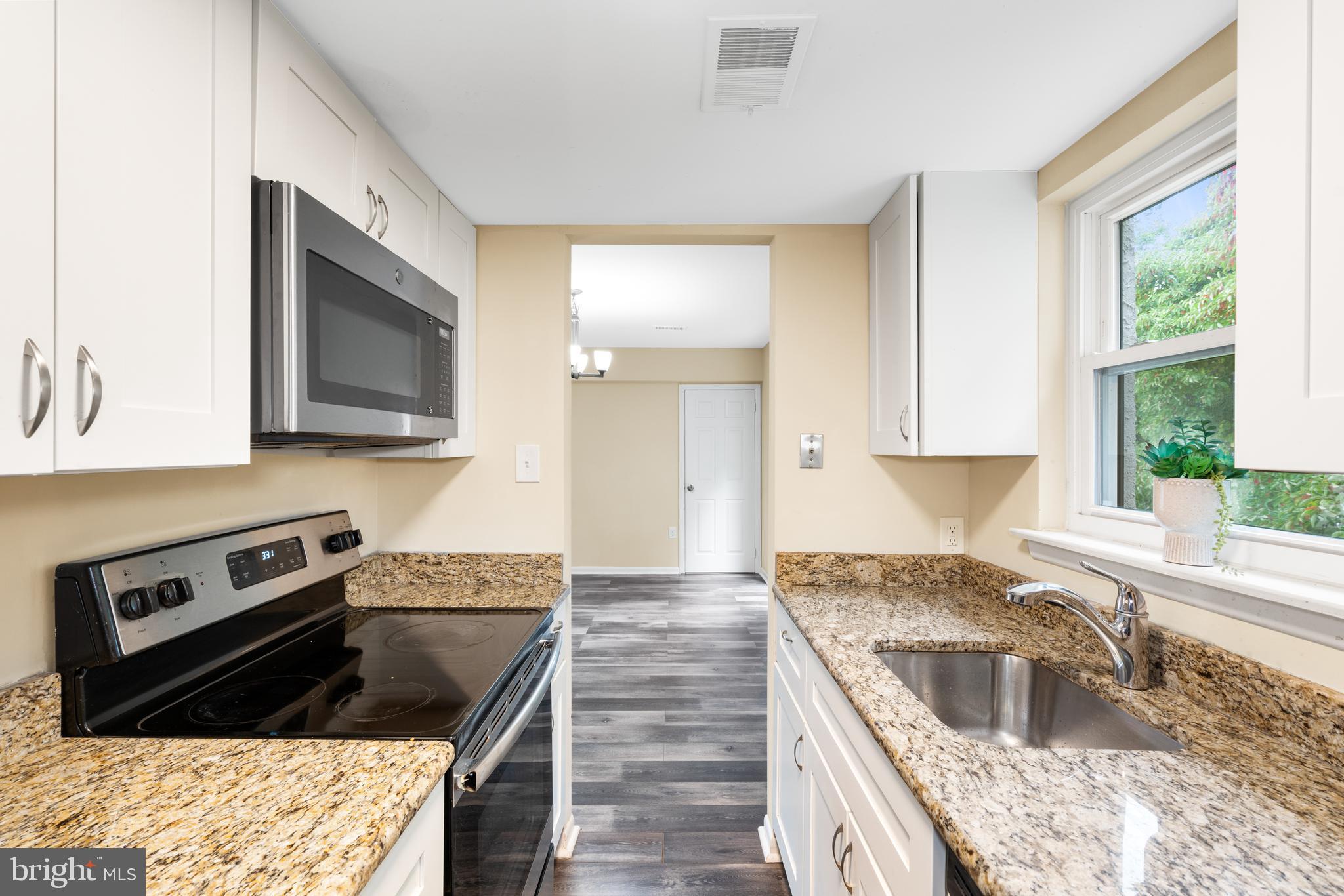 233 Township Line Road, Unit 5F Elkins Park, PA 19027 - Photo 16 of 25 a kitchen with granite countertop a stove sink and cabinets