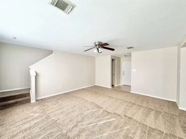an empty room with a ceiling fan and a window