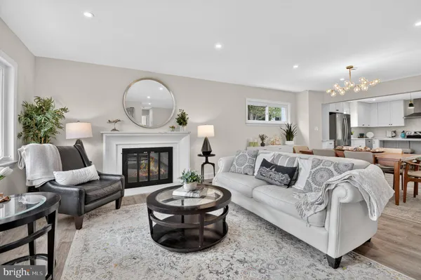 a kitchen with stainless steel appliances kitchen island wooden floors and white cabinets