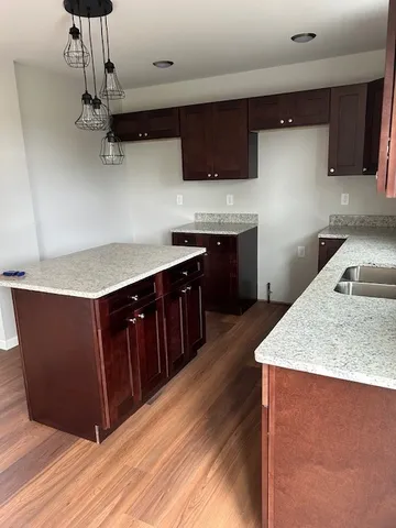 a kitchen with stainless steel appliances granite countertop a sink a stove a refrigerator and cabinets