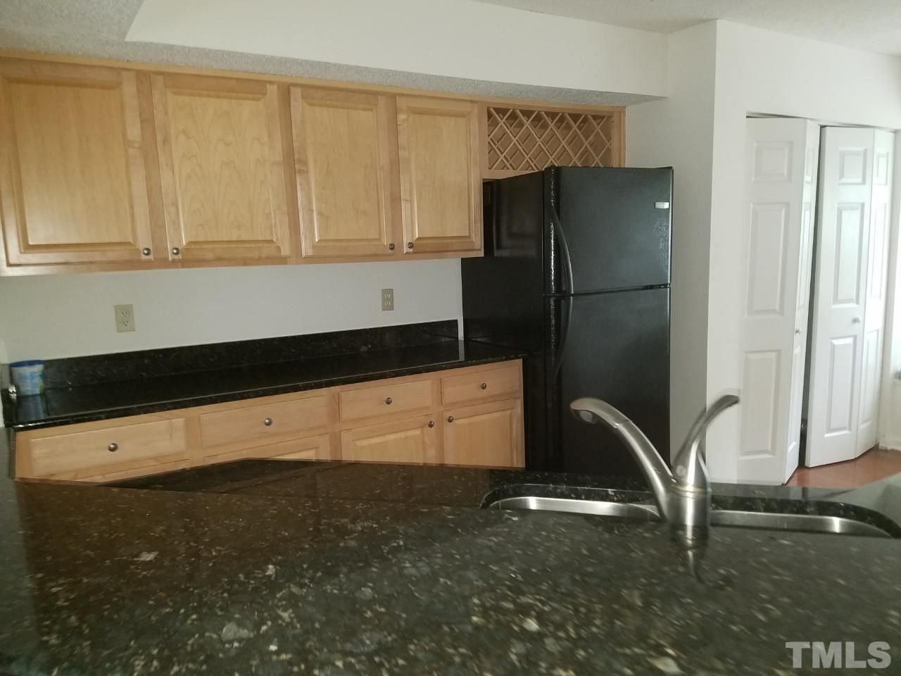 7712 Falcon Rest Circle, Unit 7712 Raleigh, NC 27615 - Photo 11 of 17 a kitchen with a sink a refrigerator and cabinets