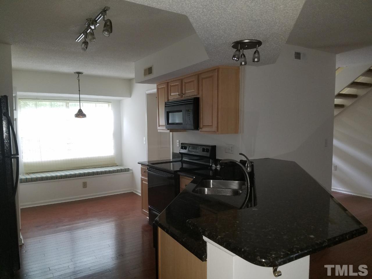 7712 Falcon Rest Circle, Unit 7712 Raleigh, NC 27615 - Photo 10 of 17 a kitchen with granite countertop a stove a refrigerator and a microwave