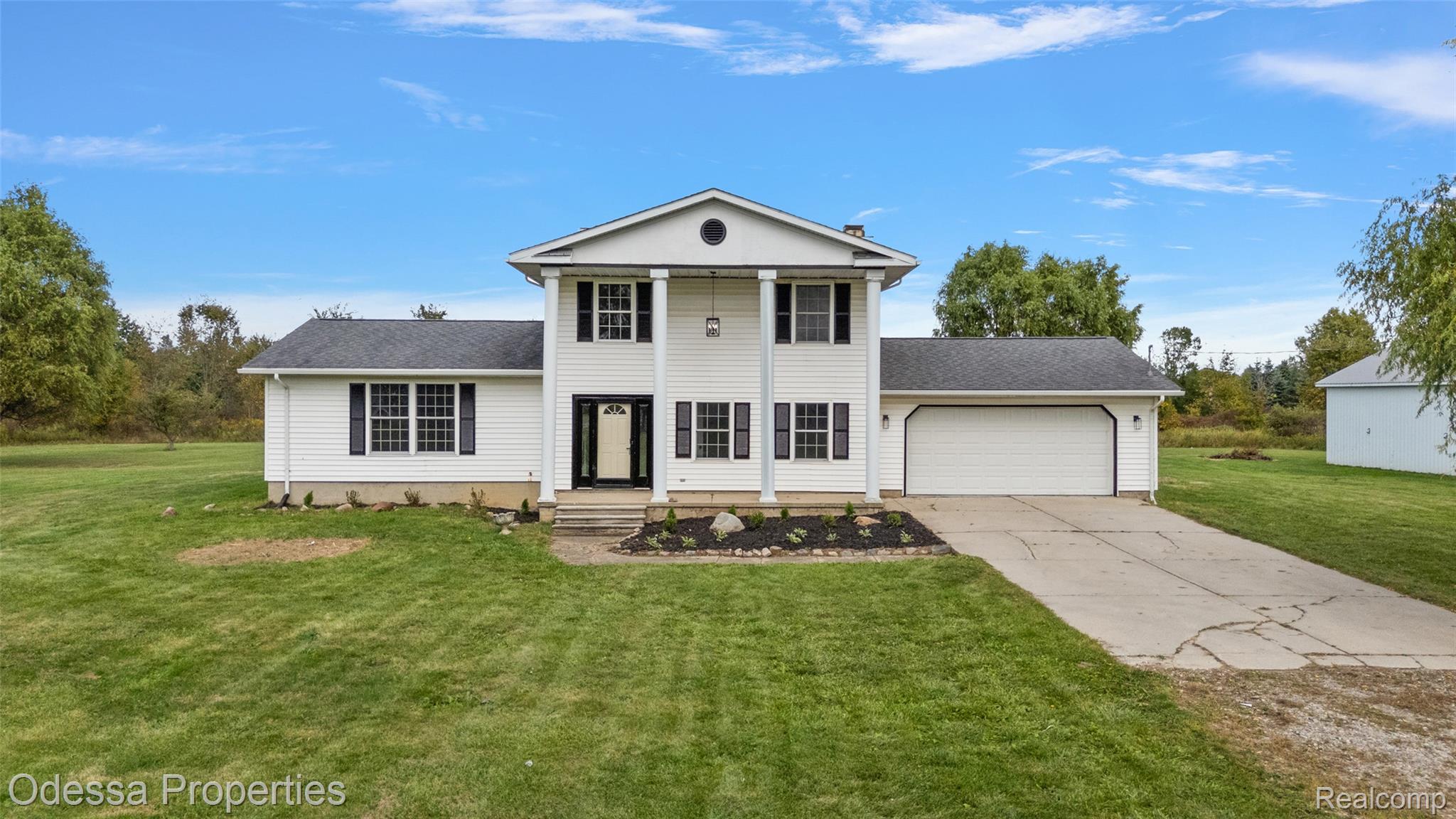 1442 Riley Center Road Memphis, MI 48041 - Photo 61 of 62 Greek revival inspired property featuring a front lawn, driveway, a garage, and a shingled roof