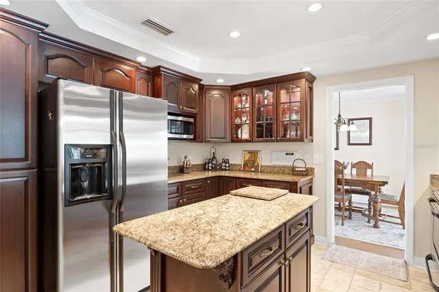 a kitchen with stainless steel appliances granite countertop a refrigerator a stove and a sink