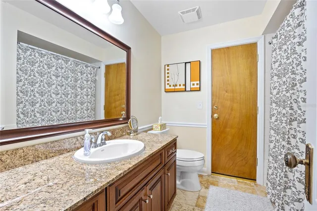 a bathroom with a granite countertop sink and a mirror
