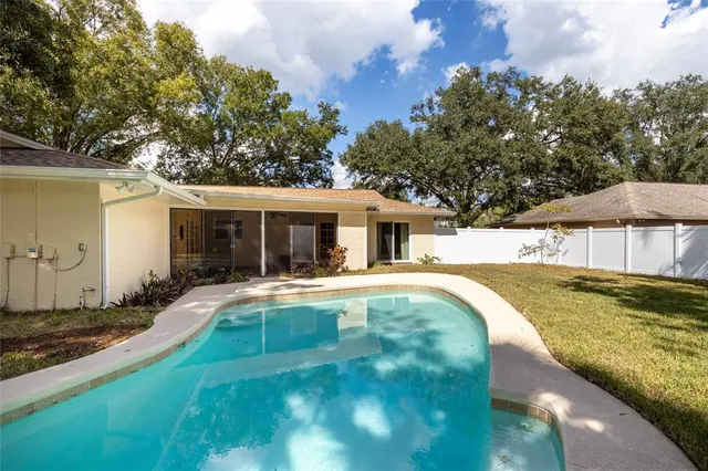 a view of a house with swimming pool and a yard