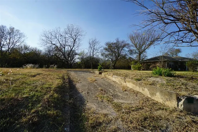 a view of backyard with wooden fence