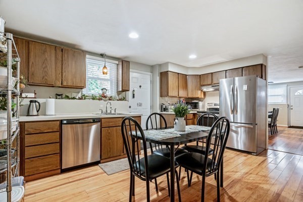25 Osborne Street Lynn, MA 01905 - Photo 23 of 40 a kitchen with granite countertop a dining table chairs refrigerator and cabinets