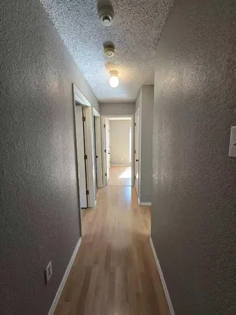 a view of a hallway with wooden floor