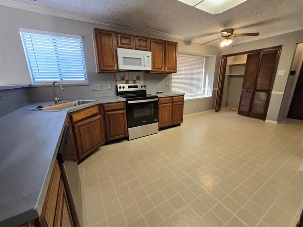 a kitchen with stainless steel appliances a stove a sink and a refrigerator