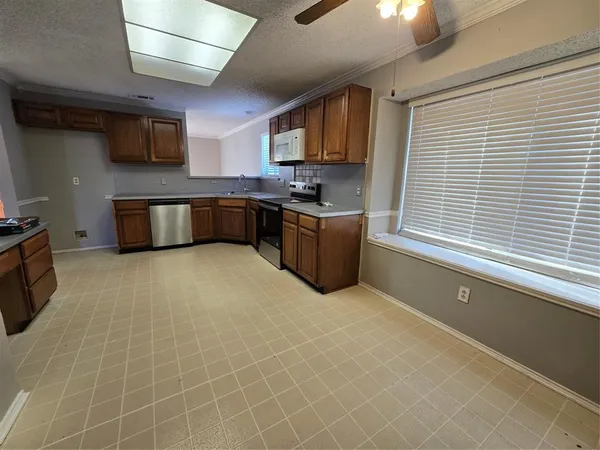 a kitchen with stainless steel appliances a stove sink microwave and cabinets