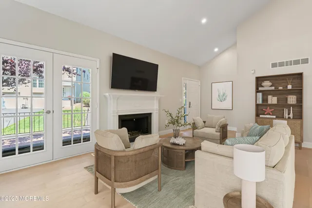 a living room with furniture a flat screen tv and a fireplace