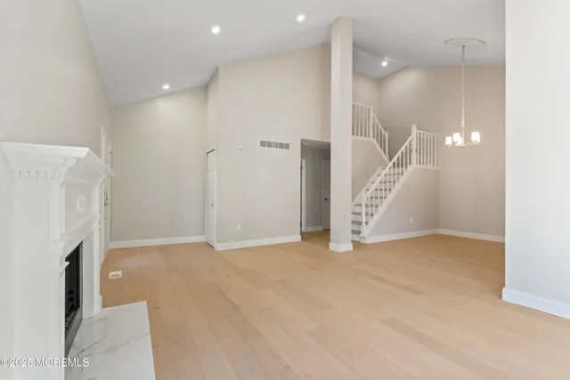 an empty room with a fireplace and entryway