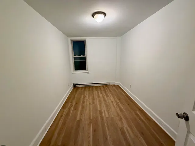 a view of a room with wooden floor and natural light
