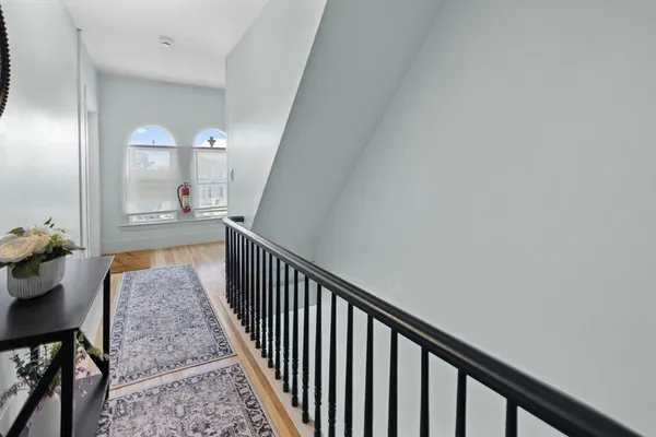 a view of a hallway view with wooden floor and staircase
