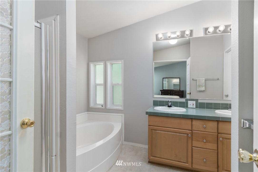 106 Slide Creek Road Longview, WA 98632 - Photo 32 of 38 a bathroom with a granite countertop sink tub and mirror