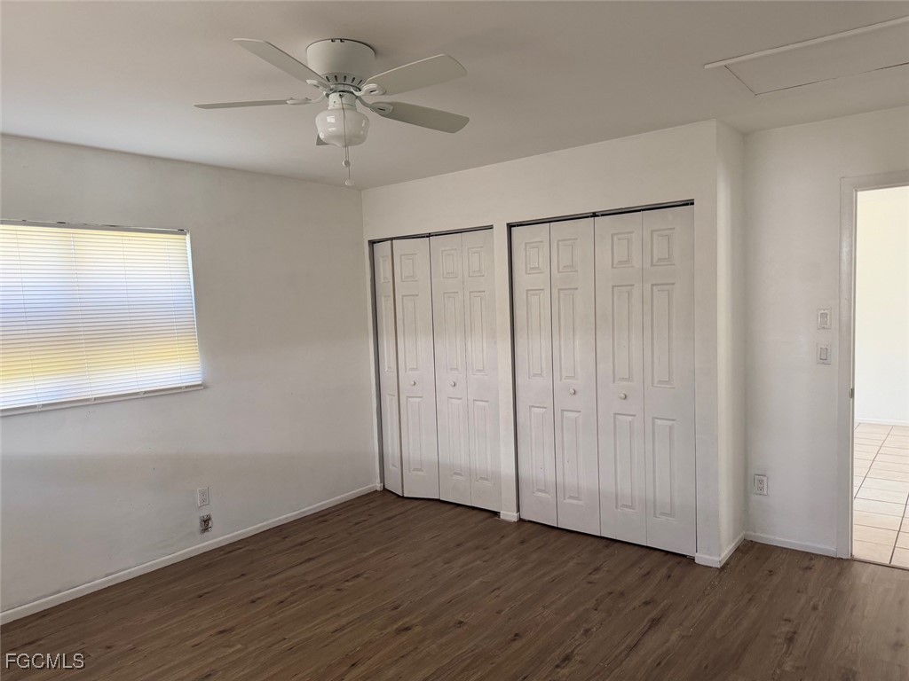 721 Gilbert Avenue South Lehigh Acres, FL 33973 - Photo 8 of 13 an empty room with wooden floor fan and windows