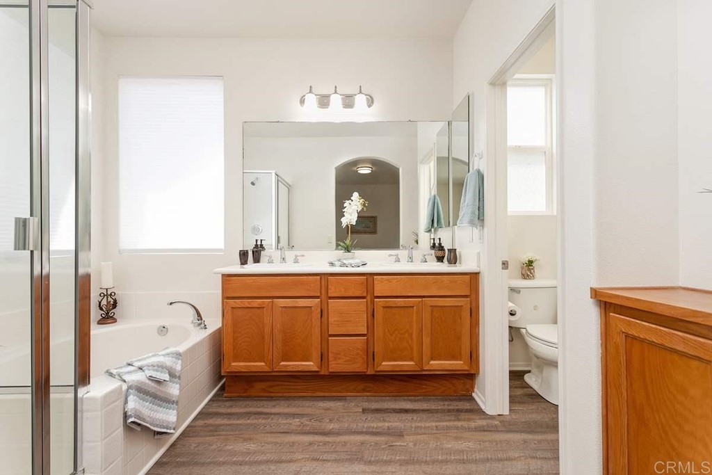 567 Big Sky Drive Oceanside, CA 92058 - Photo 16 of 27 a spacious bathroom with a double vanity sink a mirror and a bathtub