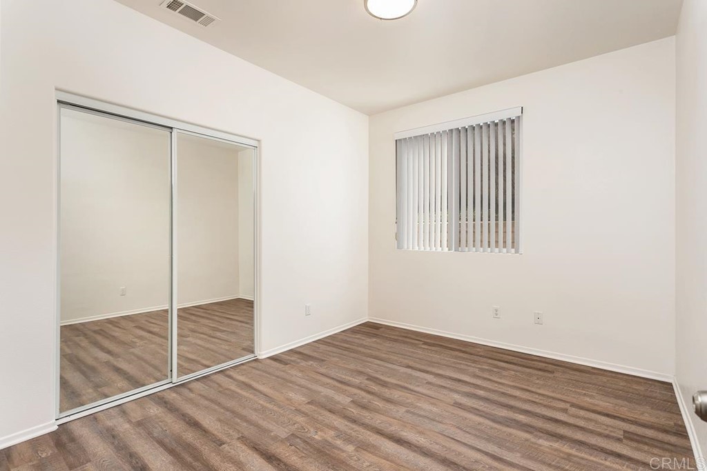 567 Big Sky Drive Oceanside, CA 92058 - Photo 19 of 27 a view of an empty room with wooden floor and a window