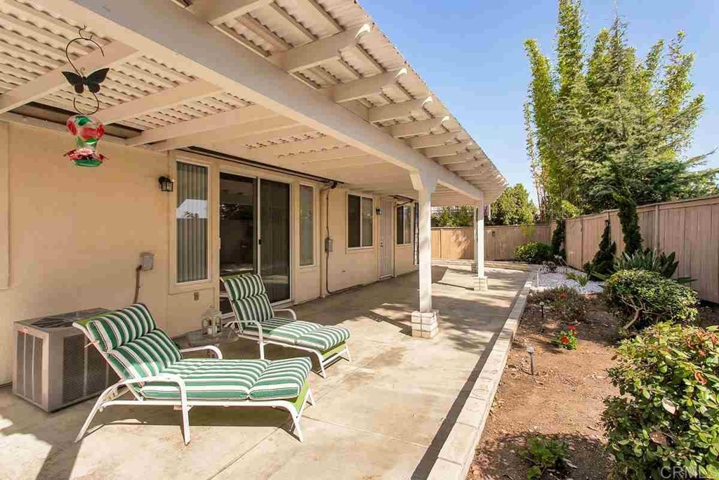 567 Big Sky Drive Oceanside, CA 92058 - Photo 26 of 27 a view of a patio with table and chairs potted plants and floor to ceiling window
