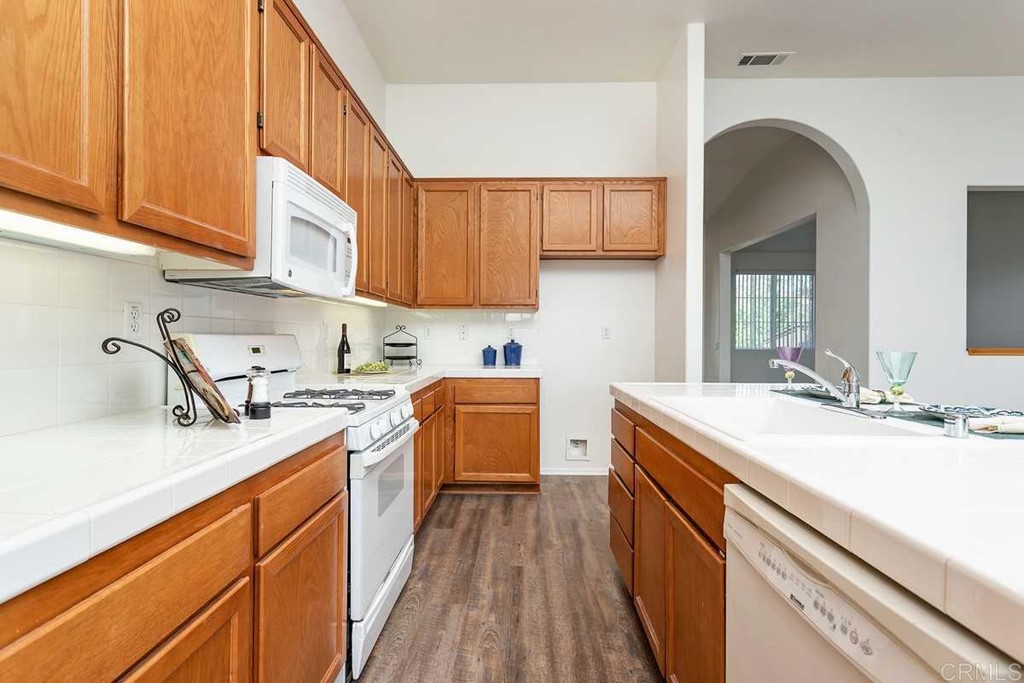 567 Big Sky Drive Oceanside, CA 92058 - Photo 10 of 27 a kitchen with stainless steel appliances granite countertop a sink stove and cabinets