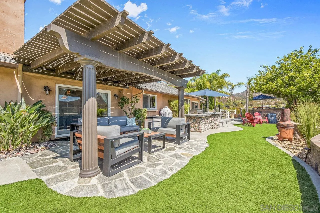 2868 Harper Ranch Road Jamul, CA 91935 - Photo 40 of 59 a view of a patio with table and chairs potted plants and palm trees