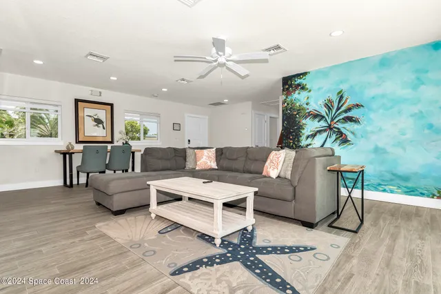 a kitchen with stainless steel appliances granite countertop a stove top oven a sink a refrigerator and white cabinets with wooden floor