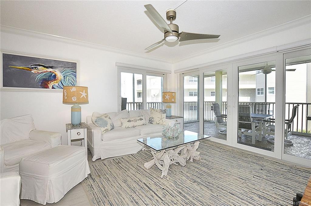 529 Northeast Plantation Road, Unit 310 Jensen Beach, FL 34957 - Photo 11 of 12 a living room with furniture and a floor to ceiling window