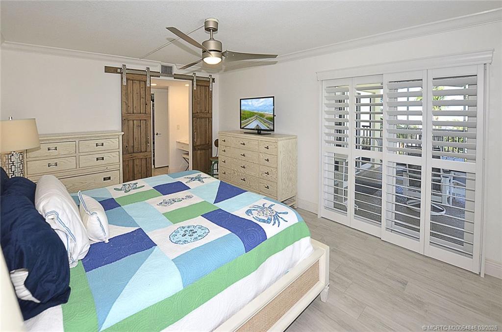 529 Northeast Plantation Road, Unit 310 Jensen Beach, FL 34957 - Photo 5 of 12 a bedroom with a bed dresser and a window