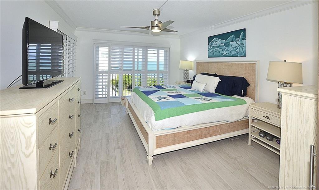 529 Northeast Plantation Road, Unit 310 Jensen Beach, FL 34957 - Photo 6 of 12 a bedroom with a bed next to a window with the outer view